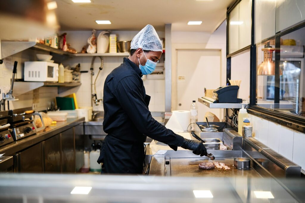 Close-up of professional latin chef man wearing a protective mask and uniform while working